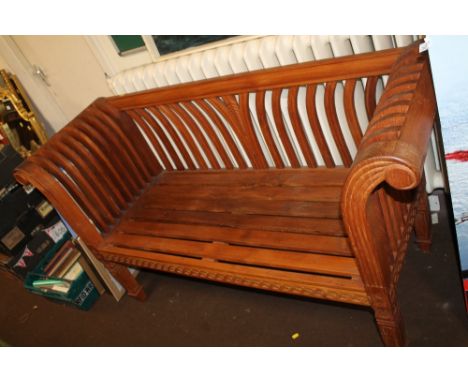 A DECORATIVE WOODEN BENCH WITH SCROLL TYPE ARMS 