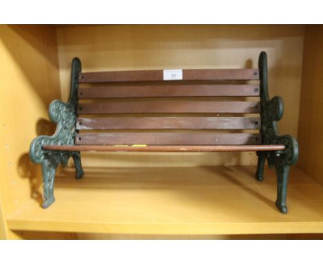 A MINIATURE GARDEN BENCH OF CAST IRON ENDS