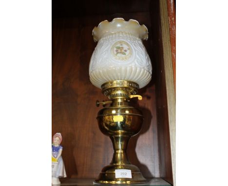 A BRASS PARAFFIN LAMP AND FLORAL SHADE 