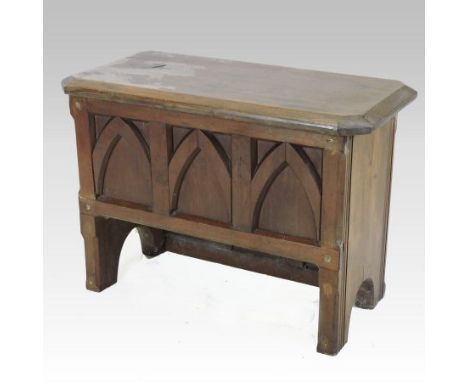An antique pitch pine coffer, of small proportions with a hinged lid and Gothic arch panelled front, 77cm