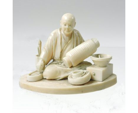 A 19th century Japanese carved ivory okimono, modelled as a man seated decorating a vase, with various tools at his feet, on 