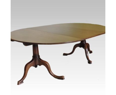 A 19th century mahogany twin pedestal dining table, of oval shape, on a turned column and tripod base, to include an addition