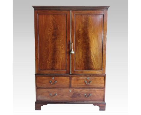 A George III mahogany dwarf linen press, enclosed by a pair of panelled doors, with drawers below, on bracket feet, 129cm