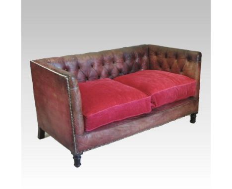 A Regency red leather upholstered button back Chesterfield sofa, of square shape, on turned mahogany legs, with loose cushion