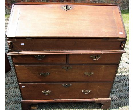 A Georgian mahogany bureau, the fall flap enclosing a fitted interior of stepped drawers, pigeon holes, central cupboard and 