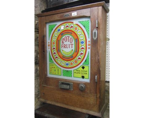 A vintage 'Roto Fruit' wall mounted oak framed fruit machine cabinet, enclosed by a glazed panelled door labelled Krafts Auto