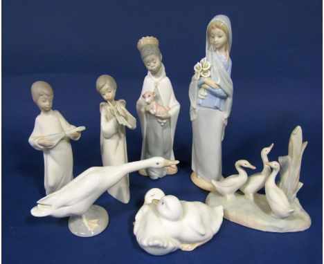 A Lladro figure of The Virgin holding lilies, a Lladro nativity figure of a young king, a Lladro goose together with a pair o