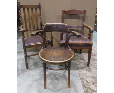 A late Victorian mahogany open elbow chair with moulded bar back over a worn leather upholstered seat raised on ring turned a