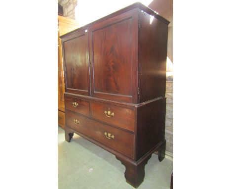 A Georgian mahogany dwarf linen press in two sections, the upper enclosed by a pair of well matched flame veneered rectangula