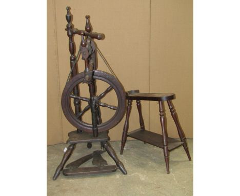 An antique foot pedal operated spinning wheel with turned frame, spoke wheel and splayed tripod supports together with a oak 