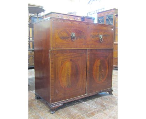 A late Georgian mahogany secretaire, the lower section enclosed by a pair of panelled doors, the secretaire fitted with a com