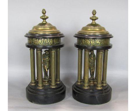 A pair of brass and black slate garnitures in the form of maidens behind Corinthian columns, in stepped circular pagoda type 