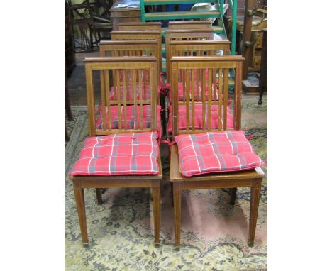 A set of eight Edwardian mahogany dining chairs with simple stick backs, over cane panelled seats, raised on square tapered s