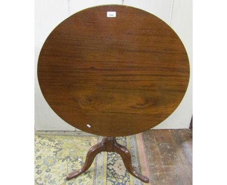 A Georgian mahogany snap top table, the circular one piece top 82cm diameter, raised on turned and fluted column and tripod b