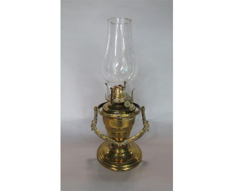 19th century pivoted brass oil lamp, the burner inscribed Queen Anne, upon a cast brass bracket with mask decoration and step