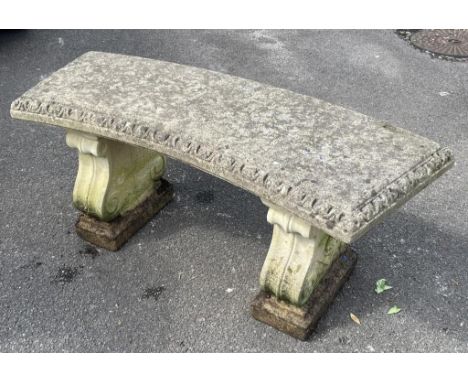 A reclaimed three sectional garden bench with curved slab seat raised on scrolled supports, 117 cm long 