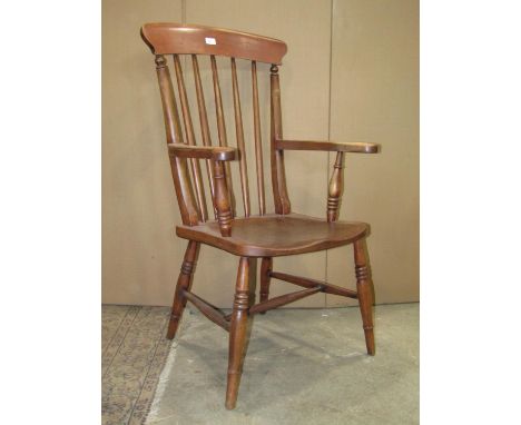 A Windsor stained elm and beechwood spindle back open armchair with saddle shaped seat raised on splayed ring turned and tape