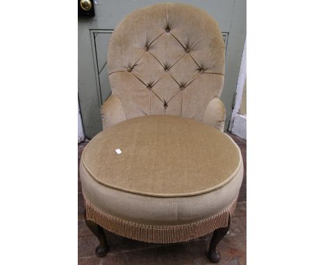 A drawing room chair with button back circular seat on short pad feet 