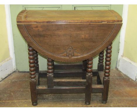 A small Georgian oak gateleg table raised on bobbin supports, the top with later carved rope work detail bearing the armorial