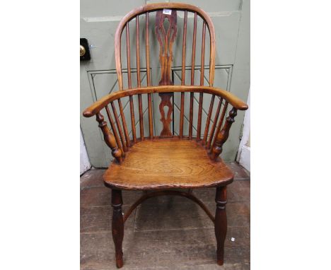 A Georgian Windsor comb back elbow chair principally in elm and ash with pierced splat and turned supports 