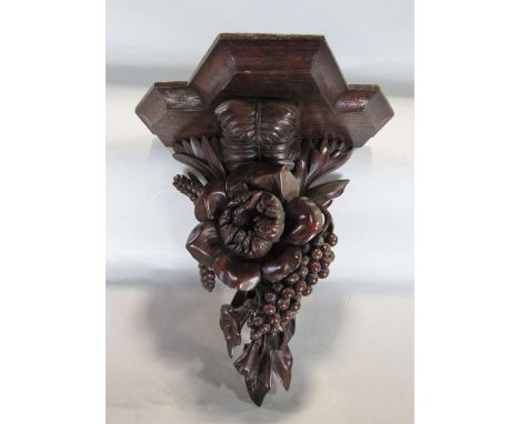 A good quality carved wall bracket, the top of serpentine form, over a floral bouquet, 30cm high 