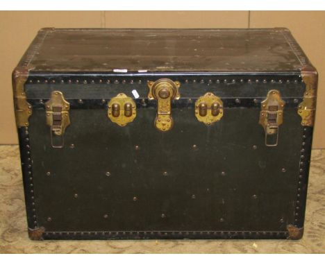 A vintage American cabin trunk with reinforced studded corners, metal fittings and stitched leather side carrying handles, th