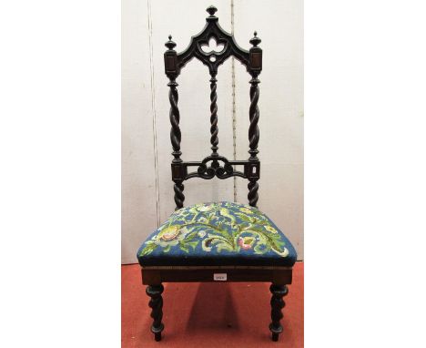 A Victorian rosewood side or nursing chair in the Gothic manner with hand worked tapestry seat, the decorative back with spir