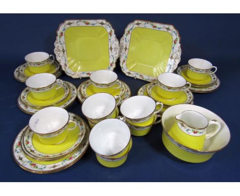 A collection of Shelley china teawares with floral border decoration above a yellow ground comprising a pair of cake plates, 