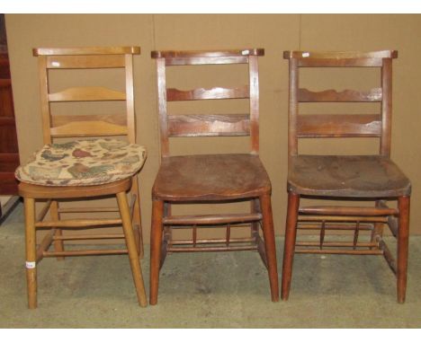 A pair of vintage stained elm and beechwood chapel chairs, with shaped bar splats and hymn book receptacles, raised on turned