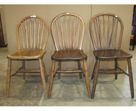 A set of six Windsor stained elm and beechwood hoop and stick back dining chairs with saddle shaped seats raised on splayed r