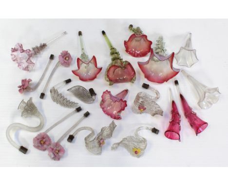 A collection of epergne branches and trumpets, mainly in pinks and clear glass in the form of leaves and fronds.