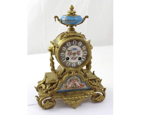 A French ormolu Sèvres-style mantel clock with blue celeste finial, floral-decorated Roman dial and cartouche panel decorated