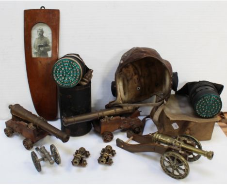 Six brass and other metal warning canons of various sizes, a cased WWII gas mask, a gas mask in a metal container, a vintage 