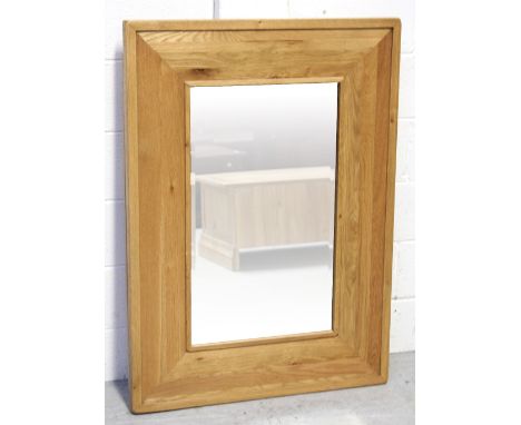 A modern light oak wall mirror, 110 x 80cm.