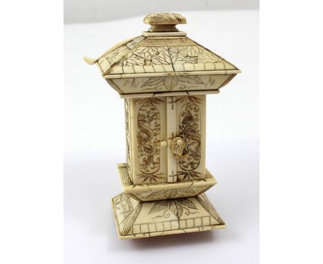 A late 19th/early 20th century carved bone and ivory part pagoda/shrine, the dragon-carved doors enclosing Buddhist official 