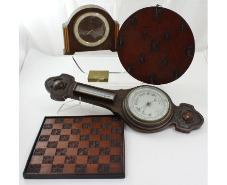 A 1950s oak mantel clock with presentation plaque dated June 1955, an oak aneroid barometer, a key hanging board and a carved