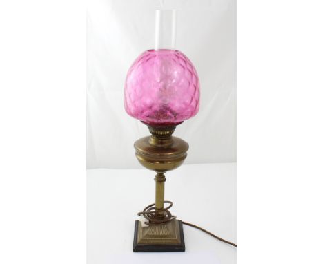 A vintage paraffin lamp with amethyst glass shade and single column support, converted to electricity, height 63cm.
