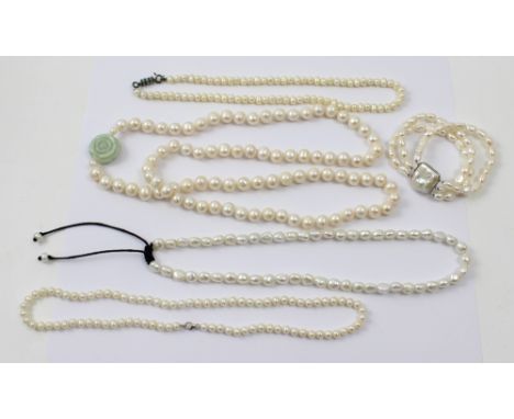 A pearl necklace with a jade rose clasp, a single pearl necklace with a silver clasp, a pearl necklace with a silk thong fast