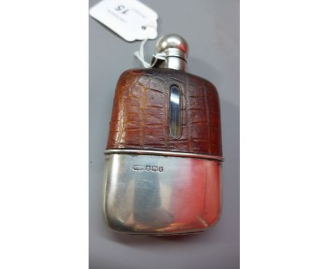 An early 20th Century crocodile skin mounted hip flask with silver top and cover