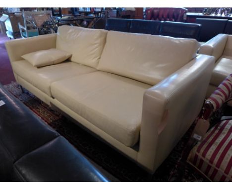 A contemporary cream leather three seater sofa raised on chrome legs