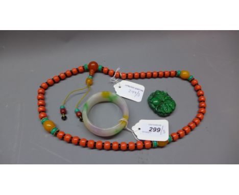 A Chinese spinach green hardstone pendant carved with a dragon, together with a Chinese jadeite bangle and a coral beaded nec