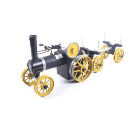 A Mamod live steam traction engine and log carrier. Black body with yellow trim and wheels, less burner pan.