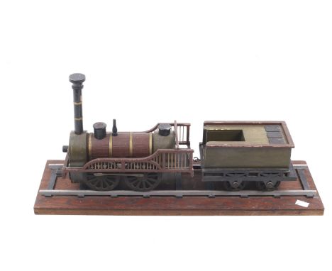 A scratch built wooden model of a steam locomotive and tender. With red body and black trim mounted on a wooden stand, L61cm.