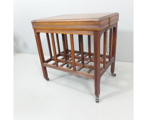 A late Victorian Aesthetic movement low table in the manner of E. W. Godwin, the hinged top enclosing a shallow void, with iv