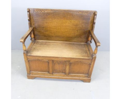 A reproduction panelled oak monk's bench. Dimensions (as bench) 105x100x46cm.Top slips easily off one hinge, so care must be 