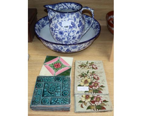 Thirteen Victorian and later pottery tiles, a jug and a basin