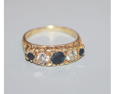 A modern Edwardian style 18ct gold, three stone sapphire and two stone diamond half hoop ring, size R.