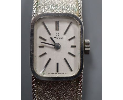 A lady's 9ct white gold Omega manual wind wristwatch, on integral textured 9ct white gold Omega bracelet, with Omega box.