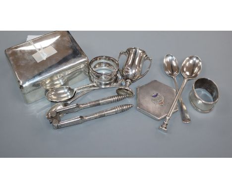 A silver cigarette box, silver pencil, two silver napkin rings, small silver trophy cup, five silver spoons, silver compact a