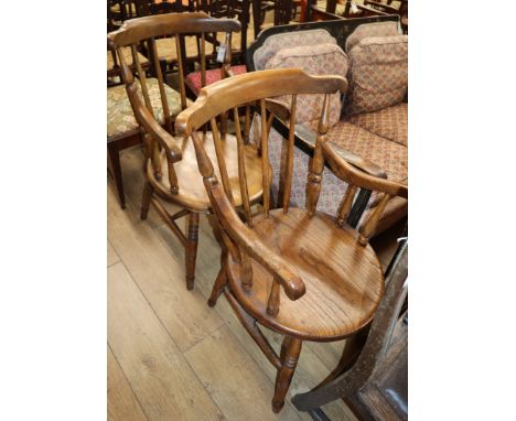 A pair of early 20th century elm comb back elbow chairs